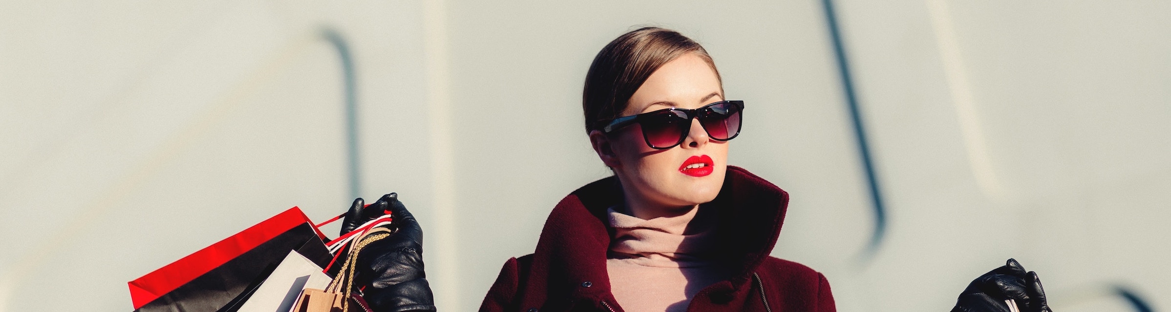 fashion model in sunglasses showing many shopping bags